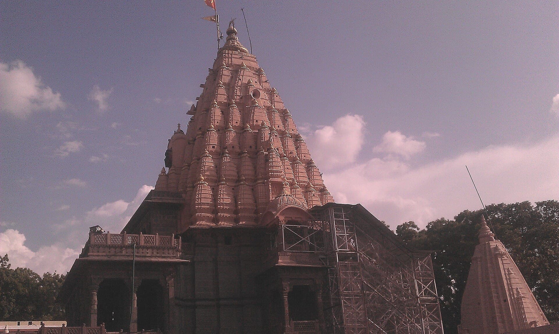 The stone spire of the Mahakaleshwar Jyotirlinga temple at Ujjain against a cloudy sky